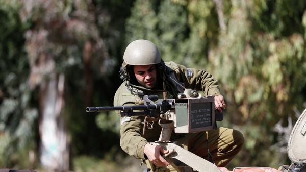 An Israeli soldier adjusts a weapon atop an armoured military ambulance near Israel's border with Lebanon - Sputnik International