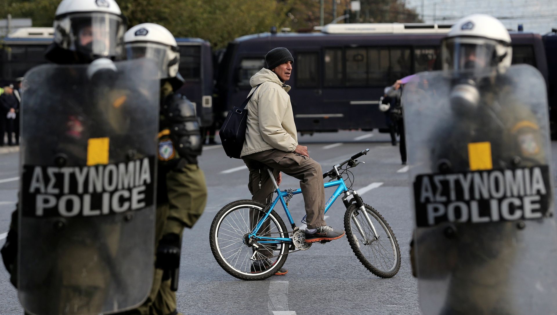 A man on a bike stands behind a police cordon guarding an anniversary rally marking the 2008 police shooting of 15-year-old student, Alexandros Grigoropoulos, in Athens A man on a bike stands behind a police cordon guarding an anniversary rally marking the 2008 police shooting of 15-year-old student, Alexandros Grigoropoulos, in Athens - Sputnik International, 1920, 14.02.2021