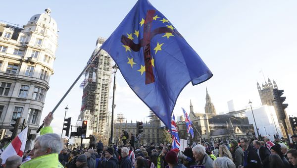 Demonstrators hold placards and flags at the Brexit Betrayal Rally, a pro-Brexit rally, outside the Houses of Parliament in London, Sunday Dec. 9, 2018 - Sputnik International