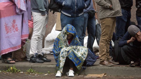 In this Sept. 1, 2015 file photo, a young child waits in line at a migrant reception center in Brussels - Sputnik International