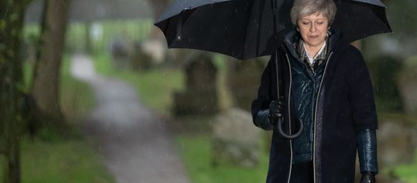 Britain's Prime Minister Theresa May shelters from the rain under an umbrella after attending a church service near to her Maidenhead constituency, west of London on December 9, 2018 Britain's Prime Minister Theresa May shelters from the rain under an umbrella after attending a church service near to her Maidenhead constituency, west of London on December 9, 2018 - Sputnik International