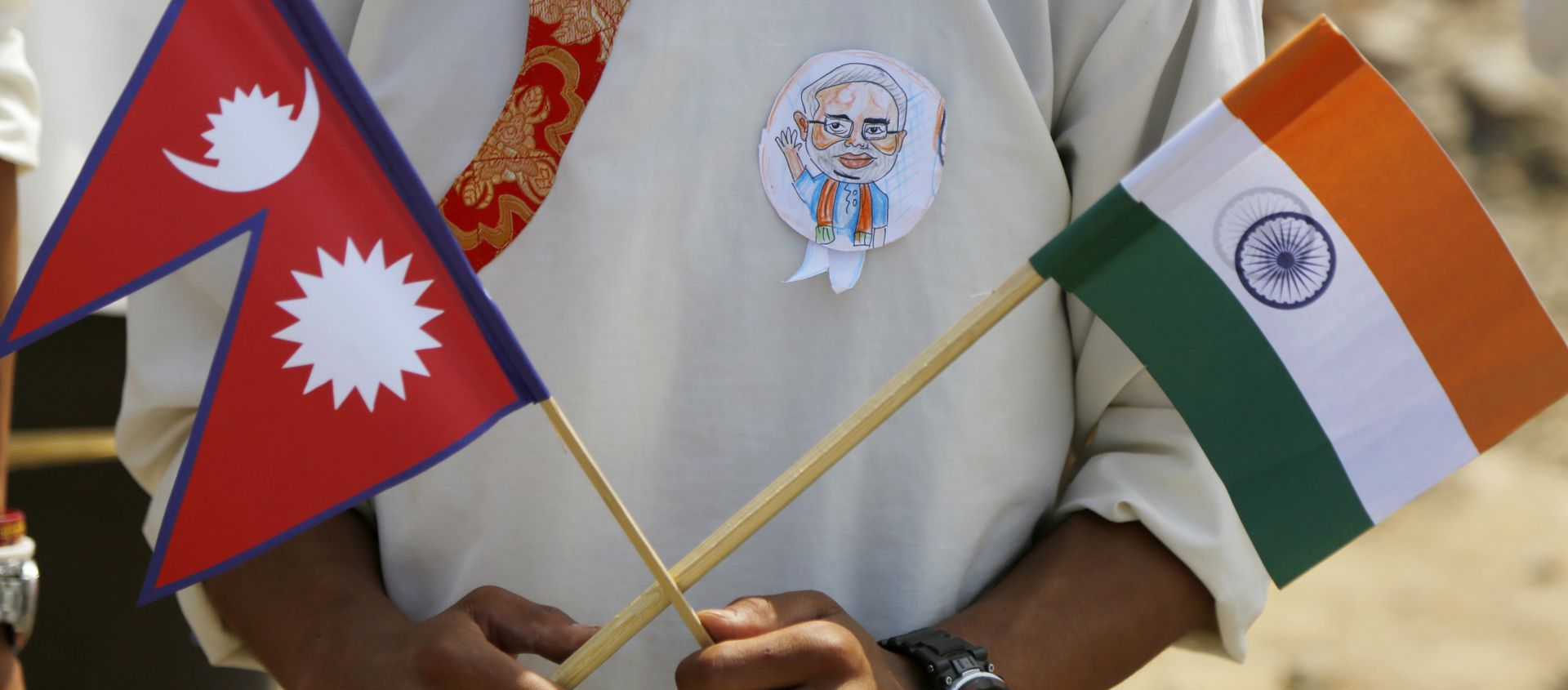 A school student holds a Nepalese and Indian flag and wears a badge with a portrait of Indian Prime Minister Narendra Modi as he waits to welcome Modi in Kathmandu, Nepal, Friday, May 11, 2018 A school student holds a Nepalese and Indian flag and wears a badge with a portrait of Indian Prime Minister Narendra Modi as he waits to welcome Modi in Kathmandu, Nepal, Friday, May 11, 2018 - Sputnik International, 1920, 21.12.2020