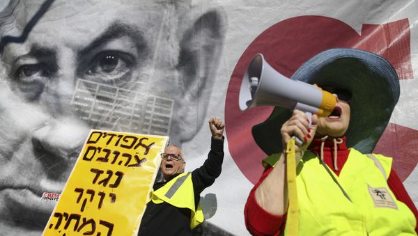 Israelis chant slogans next to a banner showing Israeli Prime Minister Benjamin Netanyahu during a protest against the rising cost of living, in Tel Aviv, Israel, Friday, Dec. 14, 2018. Sign in Hebrew reads Yellow vests against the rising cost of living. Israelis chant slogans next to a banner showing Israeli Prime Minister Benjamin Netanyahu during a protest against the rising cost of living, in Tel Aviv, Israel, Friday, Dec. 14, 2018. Sign in Hebrew reads Yellow vests against the rising cost of living. - Sputnik International