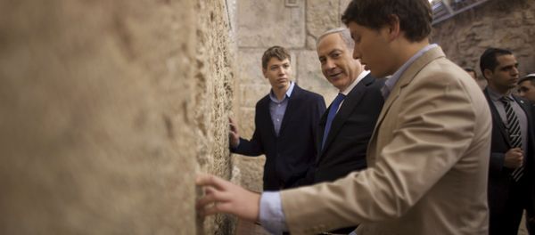 In this Jan. 22, 2013 file photo, Israeli Prime Minister Benjamin Netanyahu, center, prays with his sons Yair, background, and Avner, right, at the Western Wall, the holiest site where Jews can pray, in Jerusalem's Old City. Israeli political leaders are lashing out at Prime Minister Benjamin Netanyahu's eldest son for posting an anti-Semitic caricature aimed at his father's critics - Sputnik International