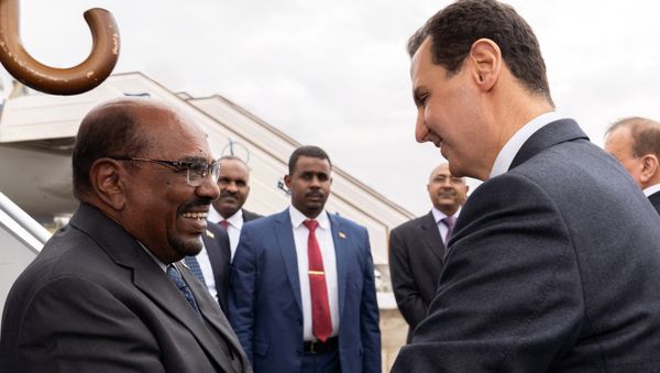 In this photo released by the Syrian official news agency SANA, Syrian President Bashar Assad, right, shakes hands with Sudan's President Omar al-Bashir in Damascus, Syria, Sunday, Dec. 16, 2018. - Sputnik International