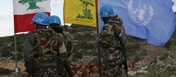 In this Thursday, Dec. 13, 2018 photo, UN peacekeepers hold their flag while standing next to Hezbollah and Lebanese flags, at the site where Israeli excavators are working, near the southern border village of Mays al-Jabal, Lebanon - Sputnik International
