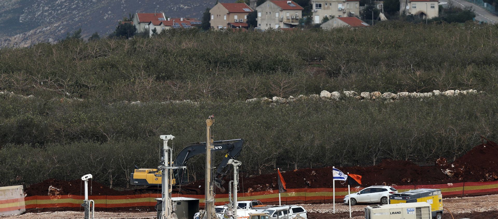 In this Thursday, Dec. 13, 2018 photo, Israeli military equipment works on the Lebanese-Israeli border in front of the Israeli town of Metula, background, near the southern village of Kafr Kila, Lebanon. As Israeli excavators dig into the rocky ground, Lebanese across the frontier gather to watch what Israel calls the Northern Shield operation aimed at destroying attack tunnels built by Hezbollah. But Lebanese soldiers in new camouflaged posts, behind sandbags, or inside abandoned homes underscore the real anxiety that any misstep could lead to a conflagration between the two enemy states that no one seems to want. - Sputnik International, 1920, 27.04.2021