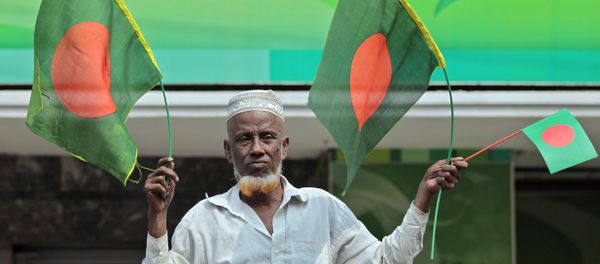 A Bangladeshi man waves national flags - Sputnik International