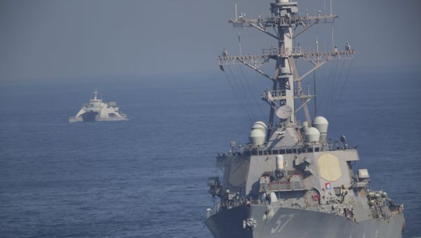 The USS Mitscher, part of a strike group led by the USS John C. Stennis aircraft carrier, sails as an Iranian Revolutionary Guard vessel shadows it on Friday, Dec. 21, 2018. - Sputnik International