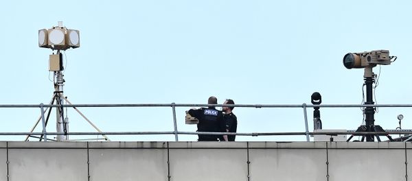 Police officers stand near equipment on the rooftop of a building at London Gatwick Airport, south of London, on December 21, 2018 Police officers stand near equipment on the rooftop of a building at London Gatwick Airport, south of London, on December 21, 2018 - Sputnik International