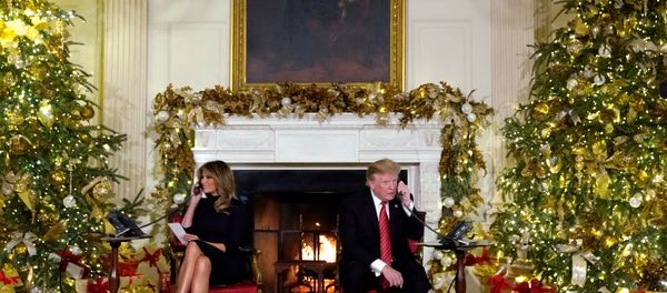 U.S. President Donald Trump and first lady Melania Trump participate in NORAD Santa tracker phone calls from the White House in Washington, U.S. December 24, 2018 - Sputnik International