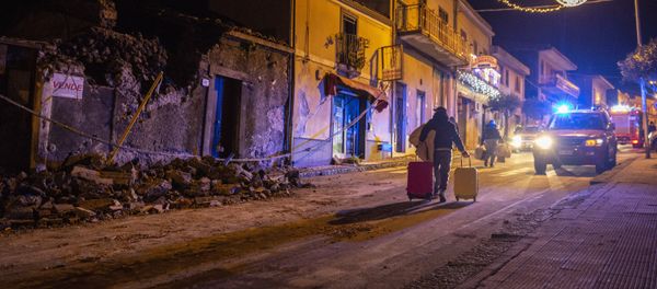 A man carries his belongings as he walks past debris of a partially collapsed house in Fleri, Sicily Italy, Wednesday, Dec. 26, 2018 A man carries his belongings as he walks past debris of a partially collapsed house in Fleri, Sicily Italy, Wednesday, Dec. 26, 2018 - Sputnik International
