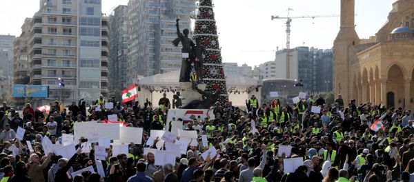 Anti-government protesters inspired by the French movement Yellow Vests (Gilets jaunes) hold Lebanese flags and chant slogans in Martyr's square, in central Beirut, on December 23, 2018 - Sputnik International