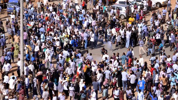 Sudanese demonstrators eject a teargas canister lobbed to disperse them as they march along the street during anti-government protests in Khartoum, Sudan December 25, 2018. - Sputnik International