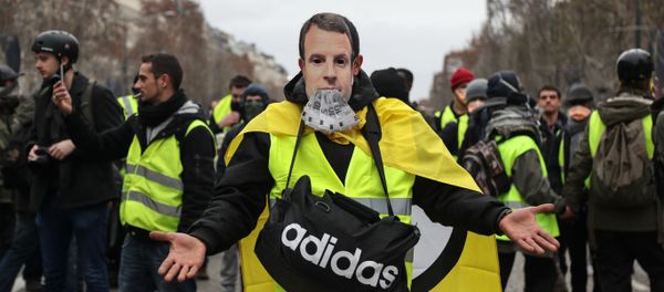 A protestor wearing a yellow vest (gilet jaune) and with a French President Emmanuel Macron mask poses on the Champs Elysees avenue in Paris on December 8, 2018 during protest against rising costs of living they blame on high taxes. - Sputnik International
