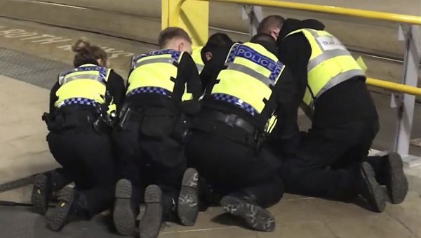 UGC issued by PA shows Police restraining a man after he stabbed three people at Victoria Station in Manchester, England, late Monday Dec. 31, 2018 - Sputnik International