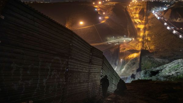 Migrants look for a place to jump the border fence to get into the U.S. side to San Diego, Calif., from Tijuana, Mexico, Saturday, Dec. 29, 2018 Migrants look for a place to jump the border fence to get into the U.S. side to San Diego, Calif., from Tijuana, Mexico, Saturday, Dec. 29, 2018 - Sputnik International
