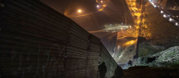 Migrants look for a place to jump the border fence to get into the U.S. side to San Diego, Calif., from Tijuana, Mexico, Saturday, Dec. 29, 2018 - Sputnik International