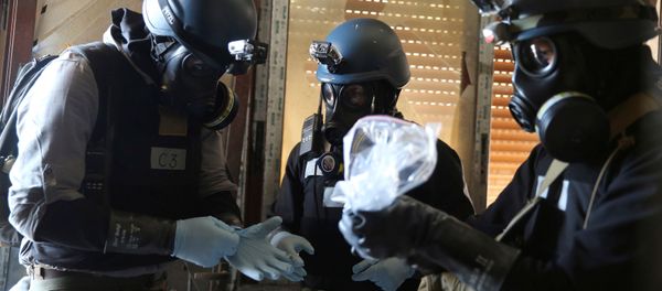 A U.N. chemical weapons expert, wearing a gas mask, holds a plastic bag containing samples from one of the sites of an alleged chemical weapons attack in the Ain Tarma neighbourhood of Damascus, Syria. (File) A U.N. chemical weapons expert, wearing a gas mask, holds a plastic bag containing samples from one of the sites of an alleged chemical weapons attack in the Ain Tarma neighbourhood of Damascus, Syria. (File) - Sputnik International