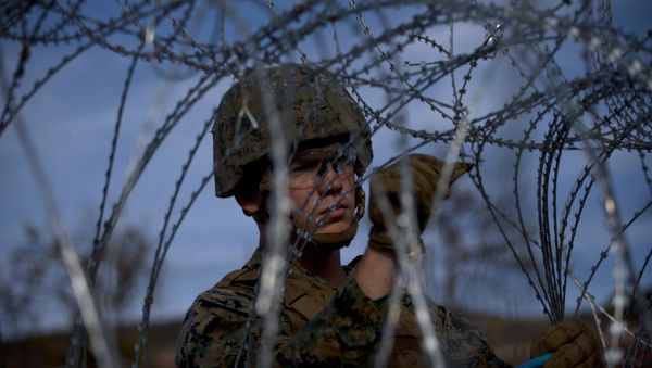 A soldier agent sets up barbed wire at the San Ysidro port of entry, at the U.S.-Mexico border, seen from Tijuana, Mexico, Thursday, Nov. 22, 2018 A soldier agent sets up barbed wire at the San Ysidro port of entry, at the U.S.-Mexico border, seen from Tijuana, Mexico, Thursday, Nov. 22, 2018 - Sputnik International