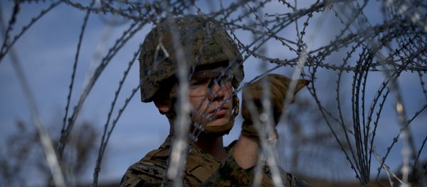 A soldier agent sets up barbed wire at the San Ysidro port of entry, at the U.S.-Mexico border, seen from Tijuana, Mexico, Thursday, Nov. 22, 2018 - Sputnik International