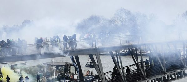 Tear gas is thrown by riot police as demonstrators wearing yellow vests try to cross a pedestrian bridge during march in Paris, Saturday, Jan. 5, 2019. - Sputnik International