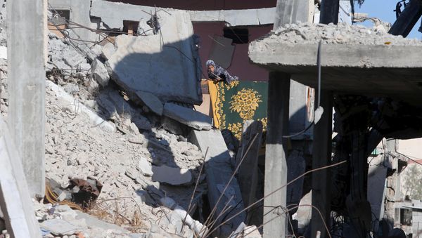 A Palestinian girl looks out from her family's house that witnesses said was destroyed by Israeli shelling during a 50-day war last summer, in Khan Younis in the southern Gaza Strip June 22, 2015. - Sputnik International