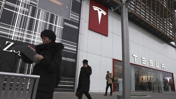 Residents walk past a Tesla store in Beijing - Sputnik International