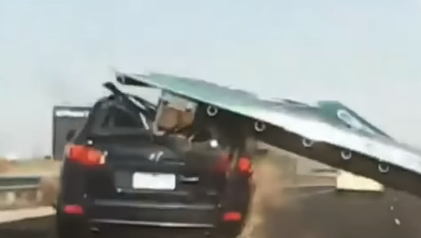 Australian woman escapes with her life after an overhead freeway sign suddenly collapses onto her vehicle - Sputnik International