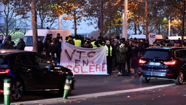 Demonstrator wearing yellow vests (Gilet jaune) hold banners reading angry VTC (Vehicle for Transport with Driver) during a protest against the rising of the fuel and oil prices on November 17, 2018 near Bercy Finance Ministry in Paris - Sputnik International