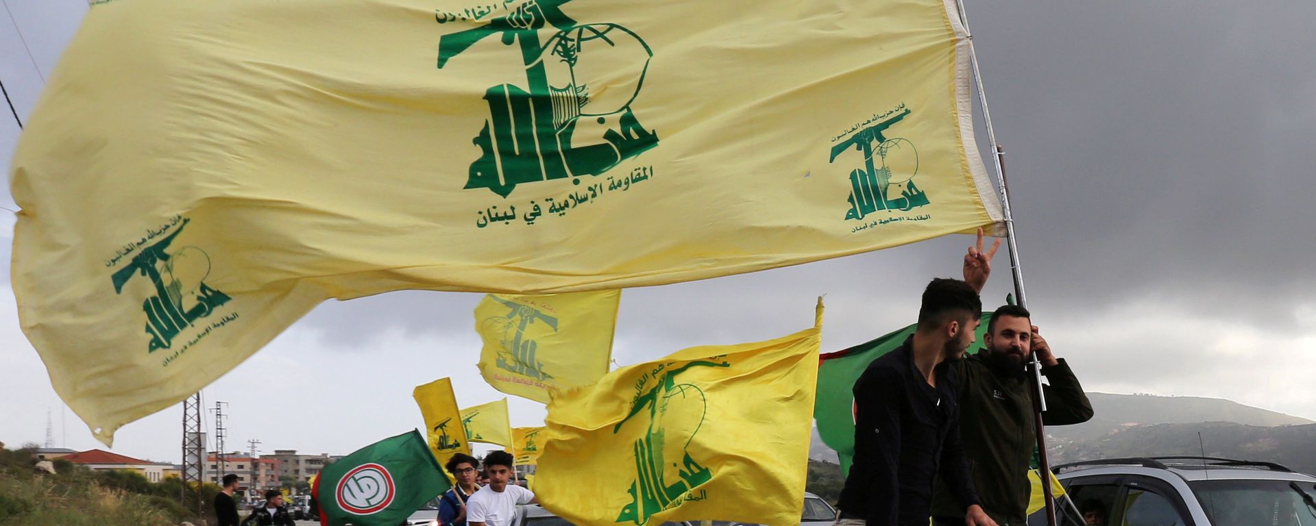 A supporter of Lebanon's Hezbollah gestures as he holds a Hezbollah flag in Marjayoun, Lebanon May 7, 2018 A supporter of Lebanon's Hezbollah gestures as he holds a Hezbollah flag in Marjayoun, Lebanon May 7, 2018 - Sputnik International, 1920, 23.10.2023