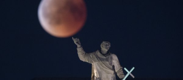The full moon appears behind the Mattielli-statue on the Hofkirche church during a blood moon eclipse over Dresden, eastern Germany, on July 27, 2018 The full moon appears behind the Mattielli-statue on the Hofkirche church during a blood moon eclipse over Dresden, eastern Germany, on July 27, 2018 - Sputnik International