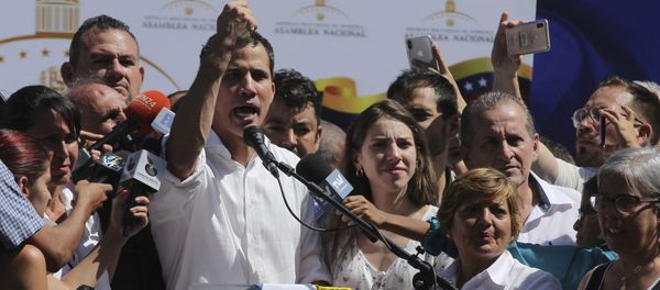 Juan Guaido, president of National Assembly, shows marks on his wrists, which he says are from handcuffs, to supporters at a rally in Caraballeda, Venezuela, Sunday, Jan. 13, 2019. The new head of Venezuela's increasingly defiant congress was pulled from his vehicle and briefly detained by police Sunday, a day after the U.S. backed him assuming the presidency as a way out of the country's deepening crisis. Guaido's wife Fabiana Rosales stands next to him, right. (AP Photo/Fernando Llano) - Sputnik International