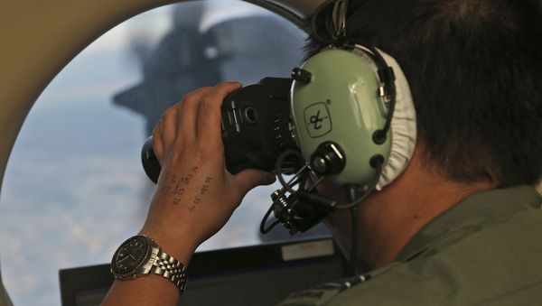 In this March 22, 2014, file photo, Flight Officer Jack Chen uses binoculars at an observers window on a Royal Australian Air Force P-3 Orion during the search for missing Malaysia Airlines Flight MH370 in Southern Indian Ocean, Australia - Sputnik International