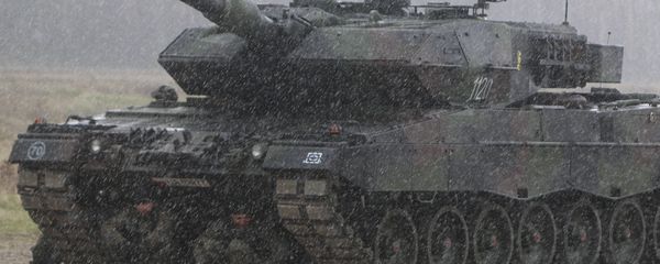Polish troops take shelter from pouring rain under the belly of a tank during a ceremony welcoming a deployment of new NATO troops in Orzysz, northeast Poland - Sputnik International