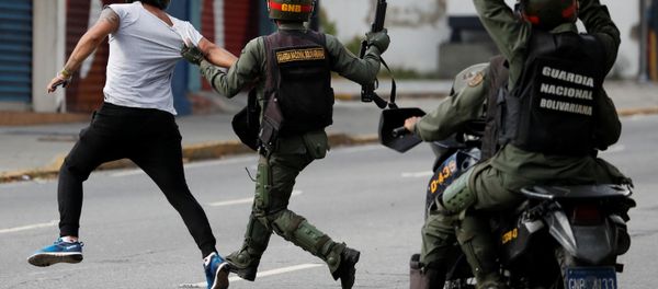 Security forces run after a demonstrator during a protest of opposition supporters against Venezuelan President Nicolas Maduro's government in Caracas, Venezuela Security forces run after a demonstrator during a protest of opposition supporters against Venezuelan President Nicolas Maduro's government in Caracas, Venezuela - Sputnik International