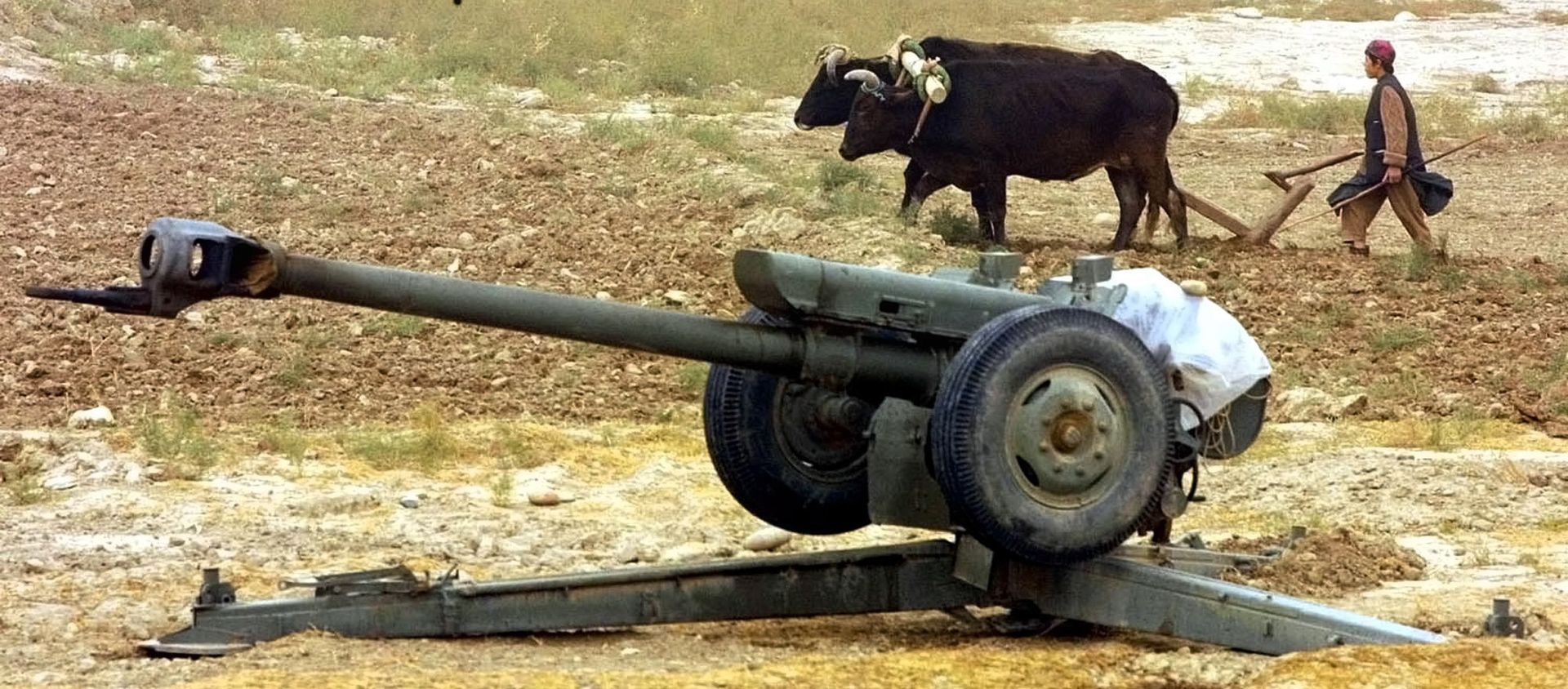 An Afghan peasant ploughs near Soviet-made D-30 howitzers just outside the village of Ai-Khanum, Northern Afghanistan, Friday Nov. 9, 2001. - Sputnik International, 1920, 02.08.2019