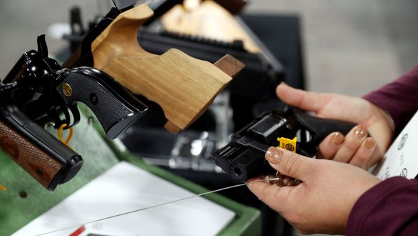 A woman looks over a Rhino revolver with a two-inch barrel in the Chiappa Firearms booth during the SHOT Show in Las Vegas - Sputnik International