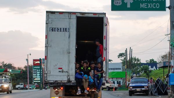 Immigrants pass by a highway sign that reads in Spanish: Mexico Border, as they take a lift in the back of a truck during their journey towards the United States, in Pajapita, Guatemala, January 17, 2019 Immigrants pass by a highway sign that reads in Spanish: Mexico Border, as they take a lift in the back of a truck during their journey towards the United States, in Pajapita, Guatemala, January 17, 2019 - Sputnik International