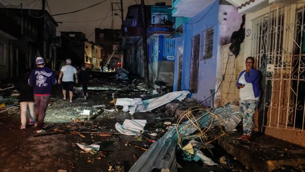 Cubans walk past debris in the tornado-hit Luyano neighbourhood in Havana early on January 28, 2019 - Sputnik International