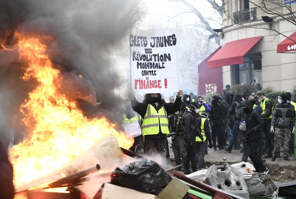 A protestor wearing a yellow vest holds a banner during the yellow vests rally in Paris, France. So-called yellow vest protests — named after the obligatory attribute of French cars — started in mid-November and have evolved into a large-scale movement against government policies and rising living costs. A protestor wearing a yellow vest holds a banner during the yellow vests rally in Paris, France. So-called yellow vest protests — named after the obligatory attribute of French cars — started in mid-November and have evolved into a large-scale movement against government policies and rising living costs. - Sputnik International
