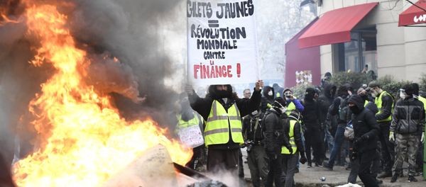 A protestor wearing a yellow vest holds a banner during the yellow vests rally in Paris, France. So-called yellow vest protests — named after the obligatory attribute of French cars — started in mid-November and have evolved into a large-scale movement against government policies and rising living costs. A protestor wearing a yellow vest holds a banner during the yellow vests rally in Paris, France. So-called yellow vest protests — named after the obligatory attribute of French cars — started in mid-November and have evolved into a large-scale movement against government policies and rising living costs. - Sputnik International