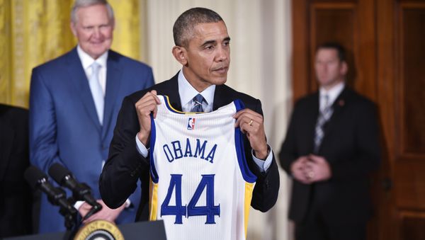 US President Barack Obama holds a jersey presented to him during an event honoring the 2015 NBA Champion Golden State Warriors in the East Room of the White House on February 4, 2015 in Washington, DC. - Sputnik International