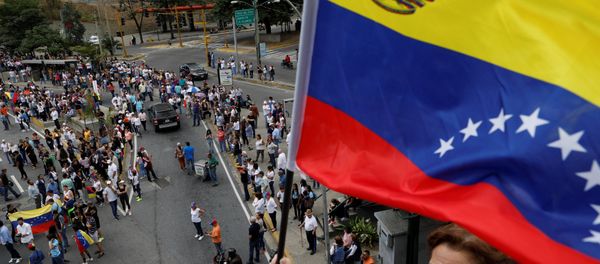 A supporter of Venezuelan opposition leader and self-proclaimed interim president Juan Guaido holds a flag A supporter of Venezuelan opposition leader and self-proclaimed interim president Juan Guaido holds a flag - Sputnik International