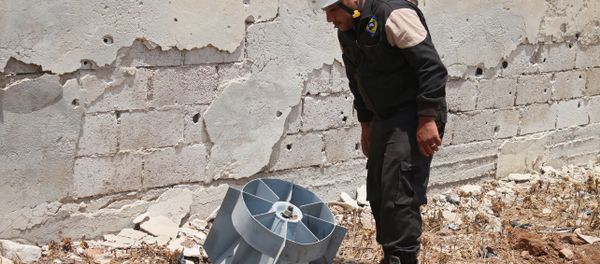 A member of the Syrian civil defence volunteers, also known as the White Helmets, stands next to the tail fin of a bomb as local bomb-disposal experts search for unexploded ordnance in a rebel-held area of Daraa on July 20, 2017 A member of the Syrian civil defence volunteers, also known as the White Helmets, stands next to the tail fin of a bomb as local bomb-disposal experts search for unexploded ordnance in a rebel-held area of Daraa on July 20, 2017 - Sputnik International