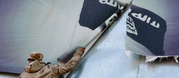 A member of the Iraqi security forces removes a banner bearing the logo of the Islamic State (IS) group in eastern Mosul on January 19, 2017 A member of the Iraqi security forces removes a banner bearing the logo of the Islamic State (IS) group in eastern Mosul on January 19, 2017 - Sputnik International
