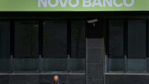 A man stands under a logo of Novo Banco Portuguese bank in Lisbon on March 31, 2017. - Sputnik International