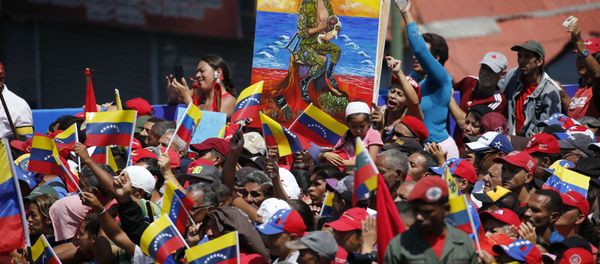 A woman holds a painting depicting a soldier breastfeeding during a pro-government rally in Caracas, Venezuela, Saturday, Feb. 2, 2019 - Sputnik International