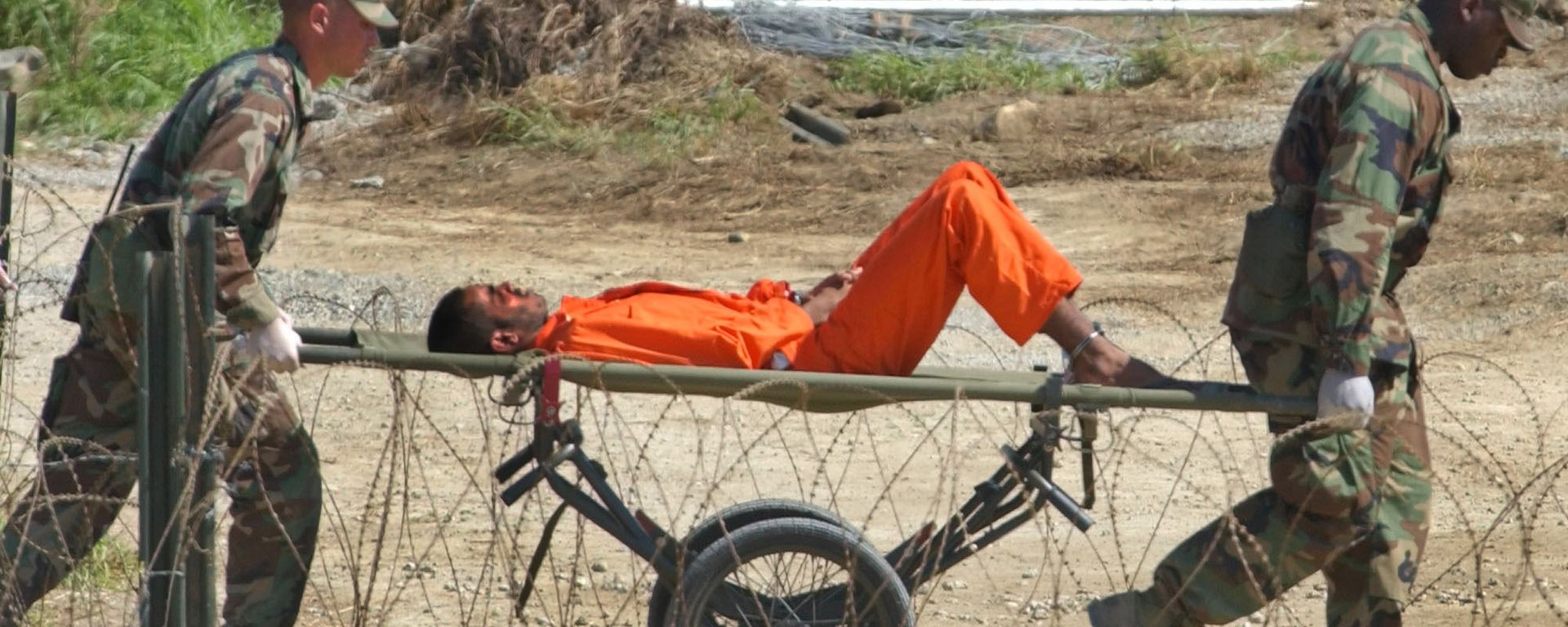 a detainee from Afghanistan is carried on a stretcher before being interrogated by military officials at the detention facility Camp X-Ray on Guantanamo Bay U.S. Naval Base in Cuba a detainee from Afghanistan is carried on a stretcher before being interrogated by military officials at the detention facility Camp X-Ray on Guantanamo Bay U.S. Naval Base in Cuba - Sputnik International, 1920, 16.09.2022