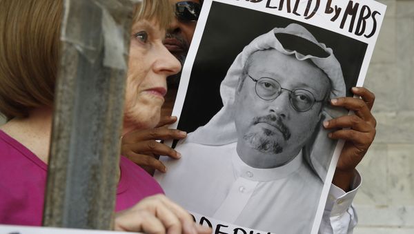 People hold signs during a protest at the Embassy of Saudi Arabia about the disappearance of Saudi journalist Jamal Khashoggi - Sputnik International